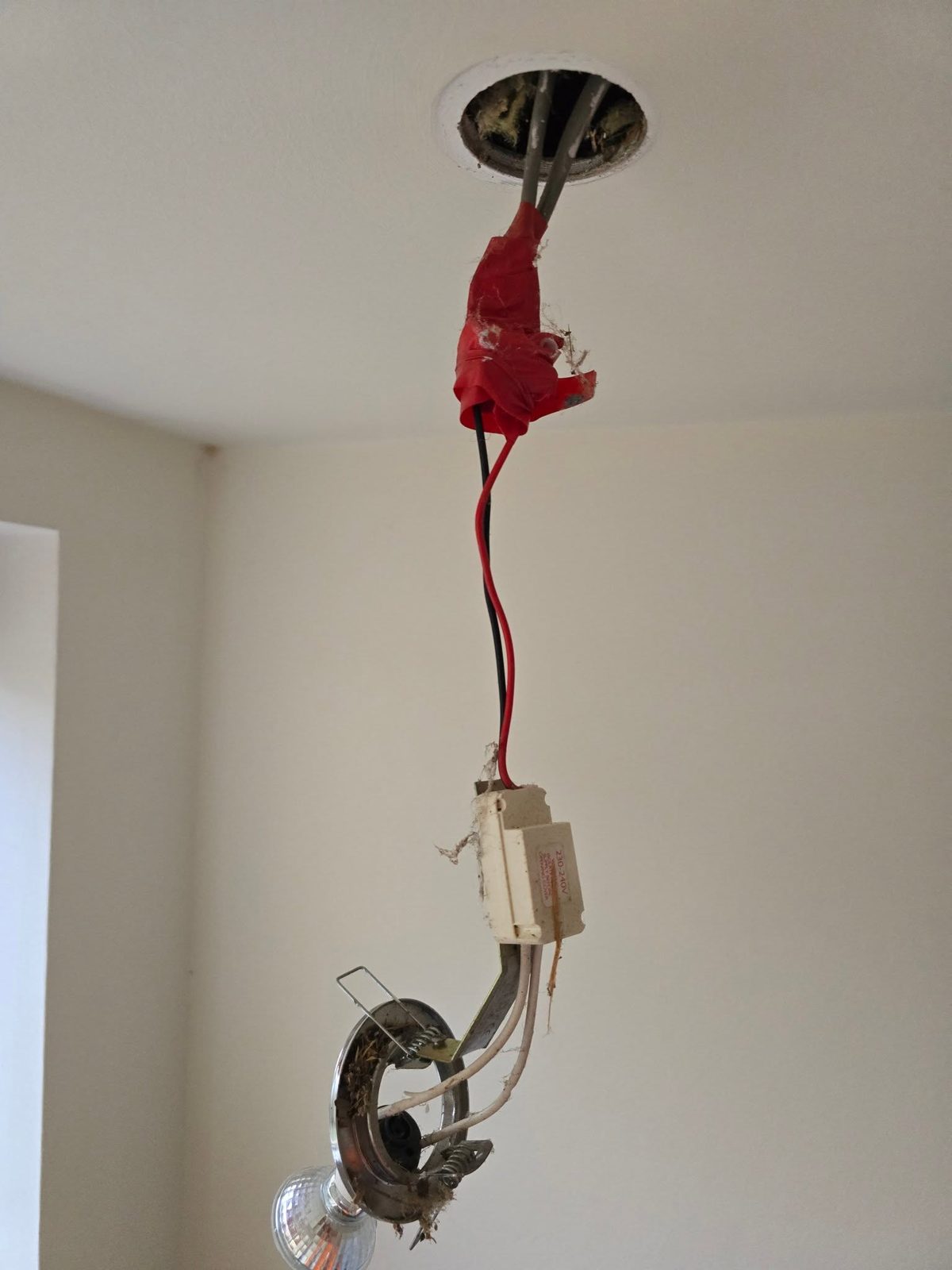 A lighting point with loose cable insulation found during an inspection