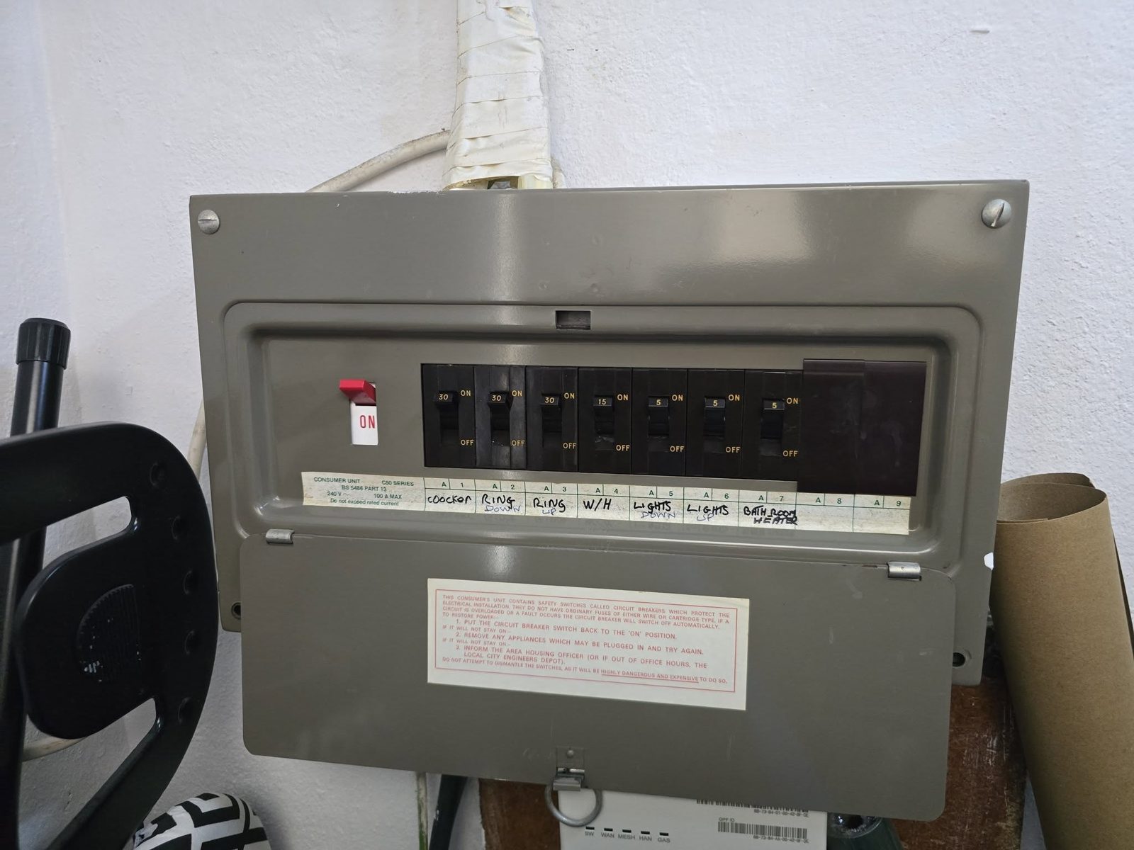 An old grey fuse board with rewireable fuses
